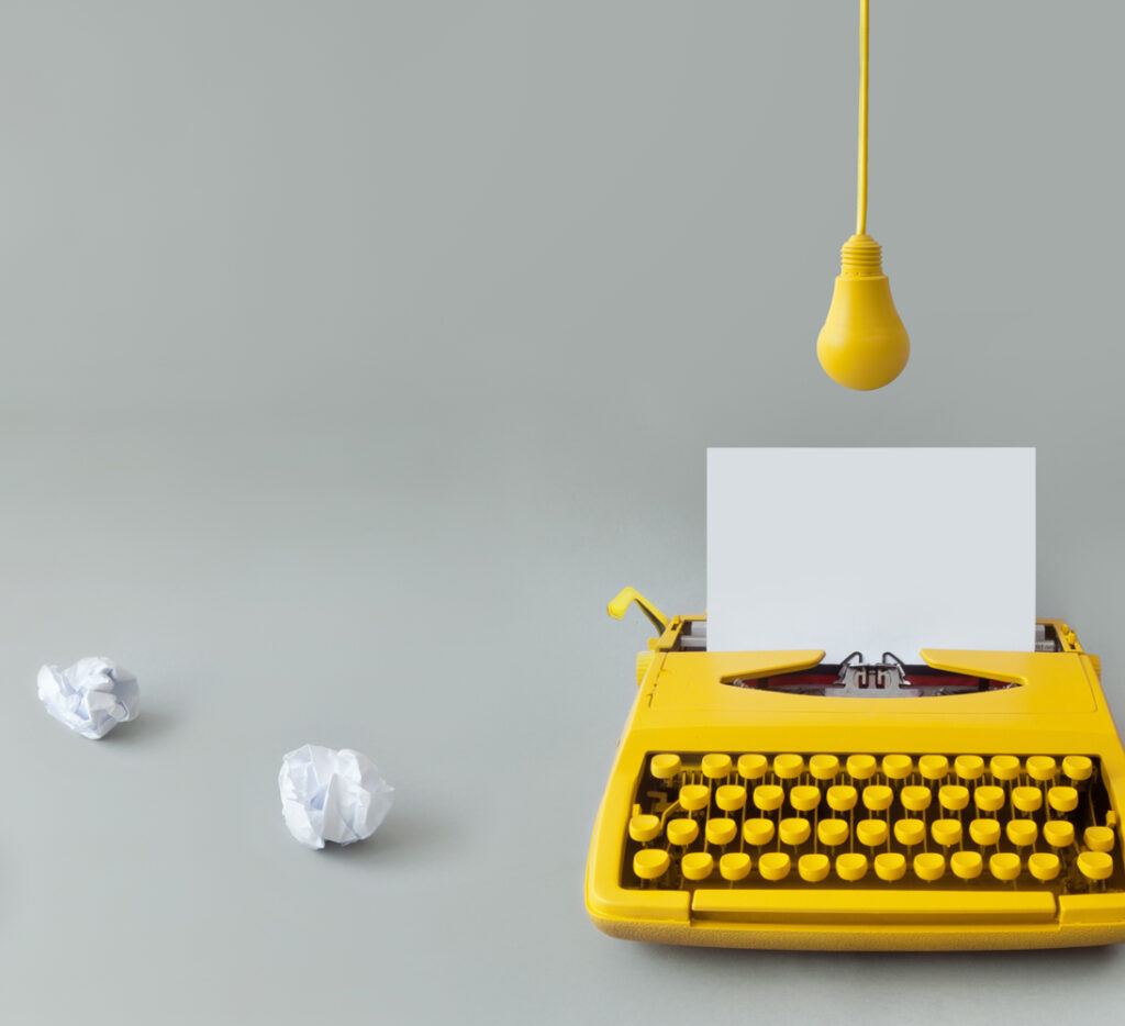 yellow typewriter with draft papers