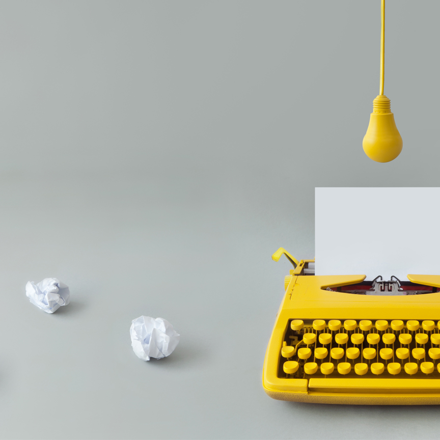 yellow typewriter with draft papers